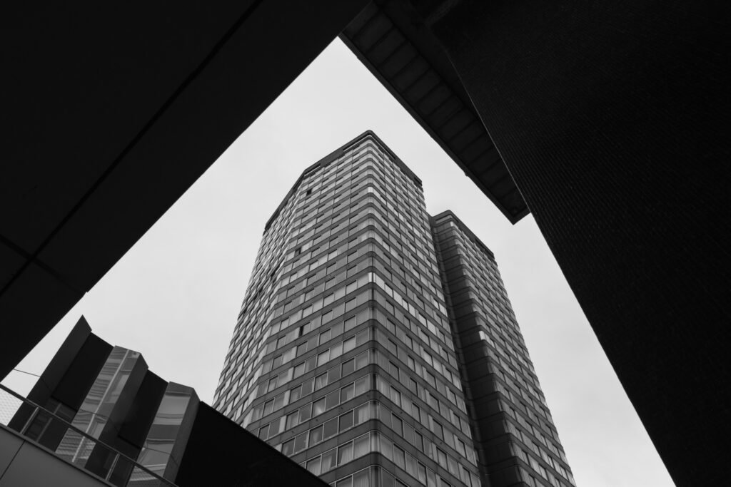Tour d'habitation vue en contre-plongée, encadrée par des bâtiments sombres