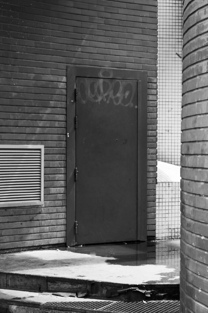 Porte métallique taguée dans un mur de briques